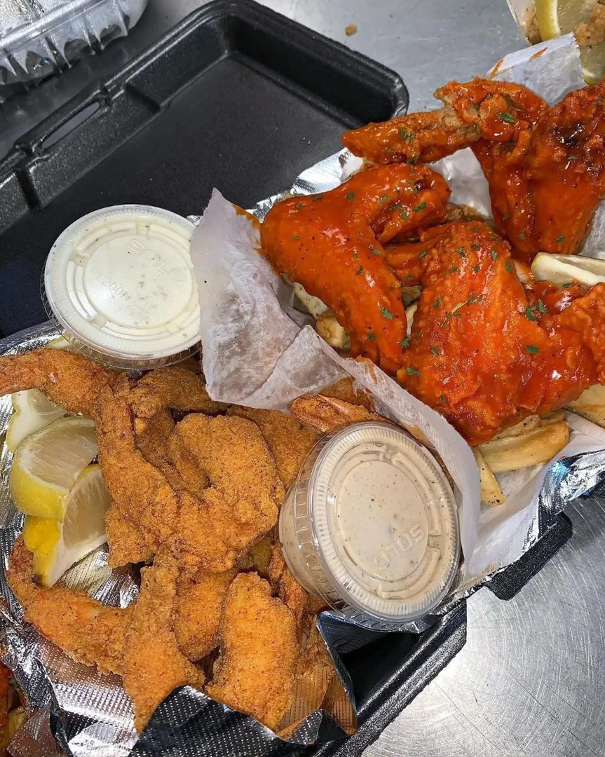 Buffalo wings over fries with fried shrimp and dipping sauces